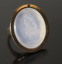 An early 19th century gold and white agate oval intaglio ring, carved with a seated figure,                                            