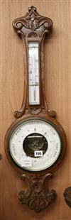 An Edwardian carved oak barometer and thermometer W.25cm                                                                               