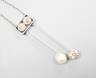 A 1940's white metal (probably platinum), three stone diamond and single stone teardrop shaped pearl set double drop pendant necklace, pendant 39mm, chain 41cm, gross weight 5.9 grams.                                    