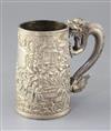 A mid-19th century Chinese silver mug, the body featuring warriors fighting to one side, with inscribed shield plaque H.13cm.          