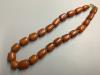 A single strand graduated barrel shaped amber bead necklace, 50 cm, gross weight 89 g.                                                                                                                                      