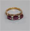 An early 20th century 18ct gold, three stone ruby and four stone diamond ring, size L.                                                 