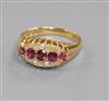 An early 20th century 18ct gold, five stone ruby elliptical shaped ring with diamond set border, size O.                               