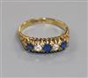 An Edwardian 18ct gold, sapphire and diamond five stone half hoop ring, size M.                                                        