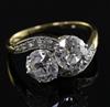 A gold and platinum, two stone diamond crossover ring with diamond set shoulders, size P.                                              