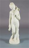 Bouzadou. A carved white marble figure of a nude girl feeding a sheath of corn to a bird on her shoulder, height 29.5in.               