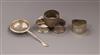 Four silver serviette rings and a silver tea strainer.                                                                                 