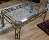 A gilt wrought iron and glass coffee table W.128cm.                                                                                    