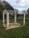 A large white painted wrought iron gazebo                                                                                              