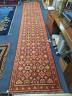 A North West Persian runner woven with rows of floral motifs, 575 x 110cm                                                                                                                                                   