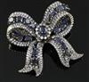 A 20th century gold, sapphire and diamond encrusted ribbon bow clip brooch,                                                            