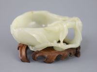 A Chinese pale celadon jade 'peach' brush washer, 17th/18th century 11.3cm at widest point, wood stand                                 