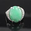 A platinum, cabochon jade and diamond set oval dress ring, size J/K.                                                                   