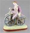 Early cycling interest: A French painted biscuit porcelain figure of a young man riding a bone shaker velocipede, height 24.5cm        