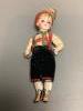 A bisque doll with boots and large glass eyes, height 15cm                                                                                                                                                                  