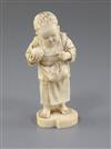 A Japanese ivory okimono of a boy holding a fruit, Tokyo School, Meiji period, 11.5cm                                                  