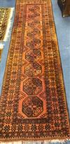 A Persian rust coloured runner, woven with a row of octagons 297 x 85cm.                                                               