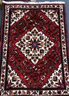 A Persian red and cream lozenge pattern rug 150 x 108cm.                                                                               