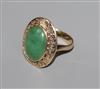 A yellow metal and oval cabochon jade dress ring, size I.                                                                              