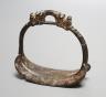 A Chinese archaic (?) bronze stirrup, 10 cms high.                                                                                                                                                                          