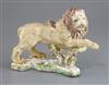 A rare and early English porcelain figure of a lion, possibly Bow, c.1750, L. 20cm, repairs and black speckling to the glaze           