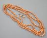 A triple strand coral bead necklace, 46cm and a pair of coral bead earrings.                                                                                                                                                