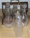 An oak three-decanter tantalus and four various glass decanters and stoppers                                                           