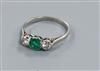 A platinum, emerald and diamond three stone ring, size O.                                                                              