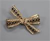 A modern 9ct gold, sapphire and diamond set ribbon bow brooch, 39mm.                                                                   