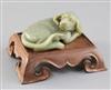 A Chinese green jade figure of a recumbent dog, length 12.5cm excl. wood stand                                                         