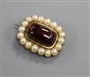 An early Victorian yellow metal, cabochon garnet and split pearl set mourning brooch, 26mm.                                            