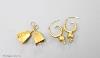 A pair of yellow metal earrings and a pair of yellow metal cowbell charms                                                                                                                                                   