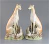 A pair of Victorian Staffordshire models of greyhounds seated with hares at their feet, 12.25in.                                       