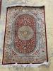 A Persian part red ground silk multi-floral patterned rug, 110 x 80cm                                                                                                                                                       