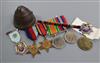 A set of World War II medals, badge and one other coin and shell cap                                                                   