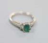 A modern white metal (engraved 750), emerald and diamond set three stone ring, size P                                                                                                                                       