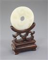 A Chinese white jade bi disc, diameter 4.6cm, wood stand                                                                               