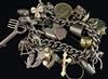 A 9ct gold curb link charm bracelet, hung with twenty nine assorted charms, including a 1911 half sovereign, gross 93 grams.           