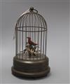 A clockwork musical singing bird automaton, the brass cage containing two birds with metal foliage, H 30cm                             