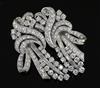 A mid 20th century white gold and diamond double clip scroll brooch, 50mm.                                                             