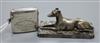 A George V silver vesta case with Papworth related inscription and an Elkington plated model of a recumbent greyhound.                 