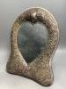 A late Victorian repousse silver mounted easel mirror with heart shaped plate, Henry Matthews, Birmingham, 1893, 35cm.                                                                                                      