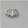 A modern platinum and yellow metal, gypsy set solitaire diamond ring, size L.                                                          