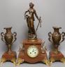 A French figurative early 20th century rouge marble clock garniture, Clock 51 cms high.                                                                                                                                     