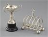 A 1940's golf interest silver toastrack surmounted by a golfer on golf ball feet by W.T. Wiseman, Birmingham toastrack 10cm.           