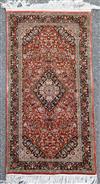 A Persian silk russet ground rug, 4ft 1in by 2ft 1in.                                                                                  