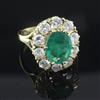 A modern 18ct gold, emerald and diamond oval cluster ring, size O.                                                                     