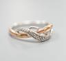 A modern two colour 9ct gold and diamond chip set crossover ring, size Q, gross weight 3.8 grams.                                                                                                                           