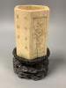 A Chinese inscribed ivory hexagonal brushpot, 17th/18th century, 12.2cm high, replacement wood base panel, age cracks, with associated hardwood stand                                                                       