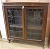 An early 20th century walnut bookcase with leaded glass doors W.121cm                                                                  